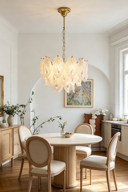 Pluma Frosted Glass Feather Chandelier | Glass, Metal | Hanging as a luxurious centerpiece over a round wooden dining table with round-back chairs in a bright classical room | vexa lamps