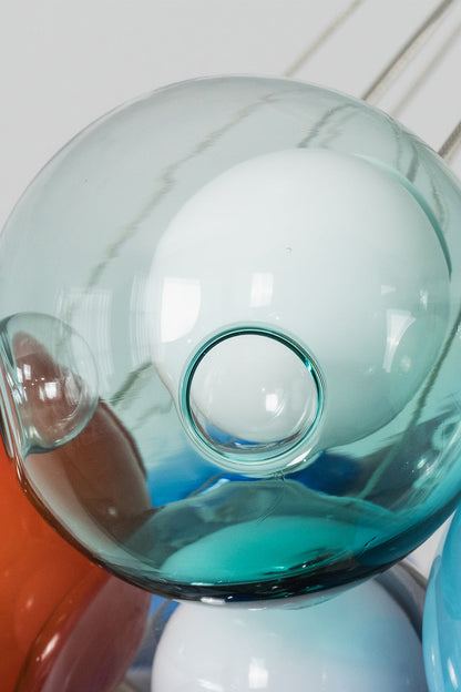 Rainbow Glass Bubble Cluster Chandelier | Glass, Metal | Close-up focus on a light mint blue glass bubble showing the glass loops and wiring top connection | Detail shot | vexa lamps