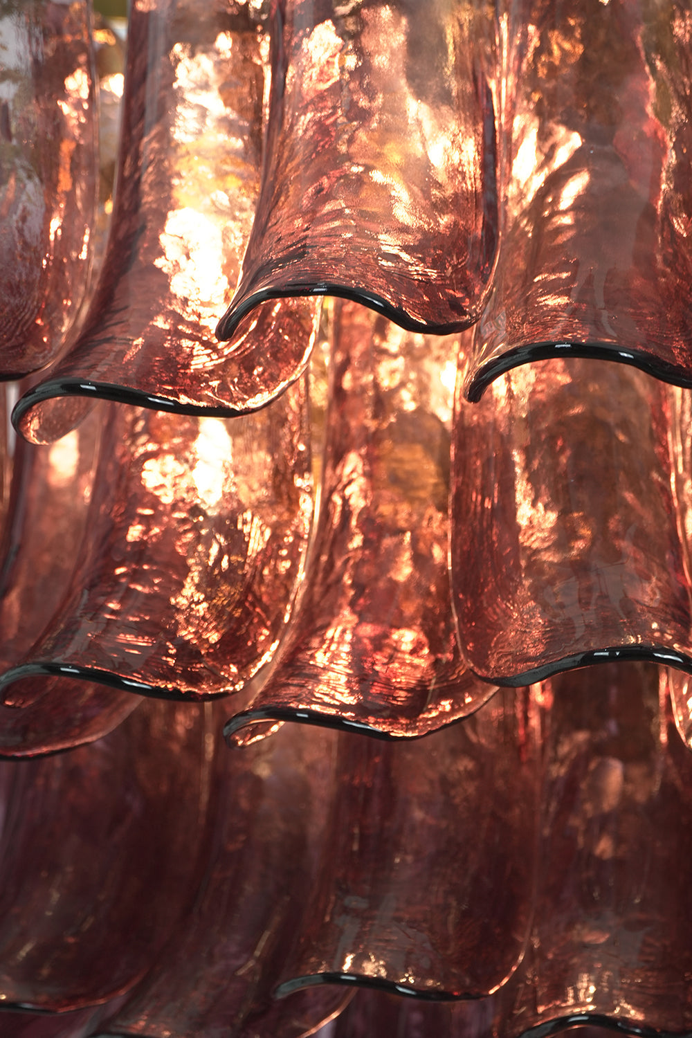 Regal Purple Cascade Chandelier | Glass, Metal | Close-up of the glowing purple glass petals with organic rippled texture | Detail shot | vexa lamps