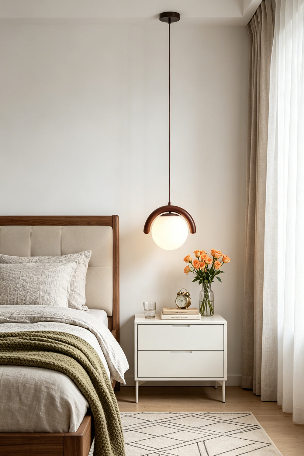 Modern single globe pendant light in a cozy bedroom | Metal, Glass | Installed over a white bedside table with flowers | vexa lamps