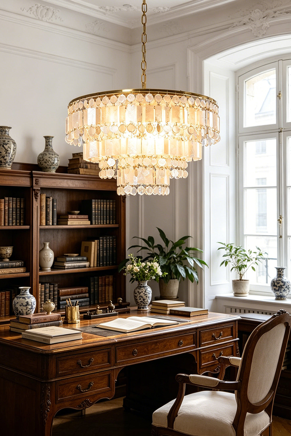 Seraphina Capiz Cascade Metal Chandelier in a stylish office setting with a wooden desk and bookshelves.