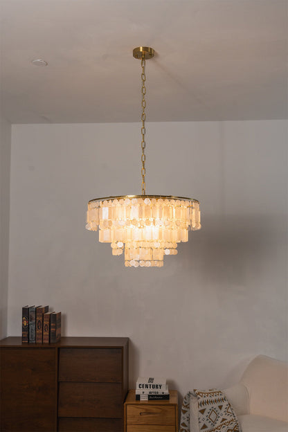 Seraphina Capiz Cascade Metal Chandelier in a warm gold tone, featuring capiz shell discs, hanging in a modern dining space.
