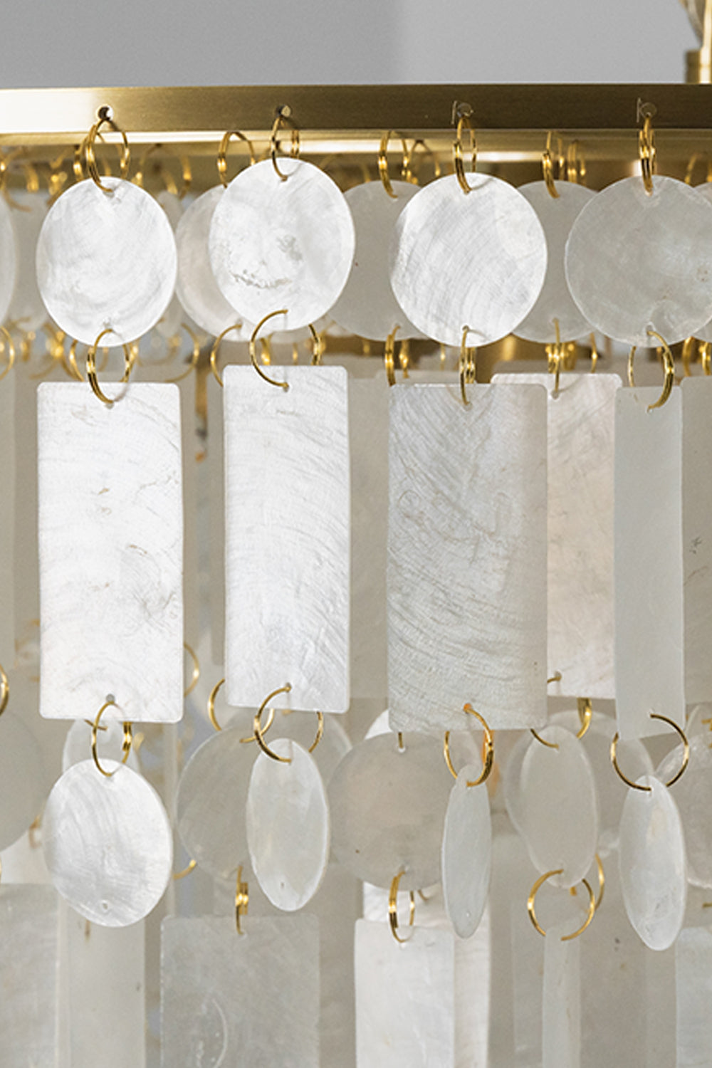 Close-up of the Seraphina Capiz Cascade Metal Chandelier showcasing capiz shell discs and gold-tone metal.