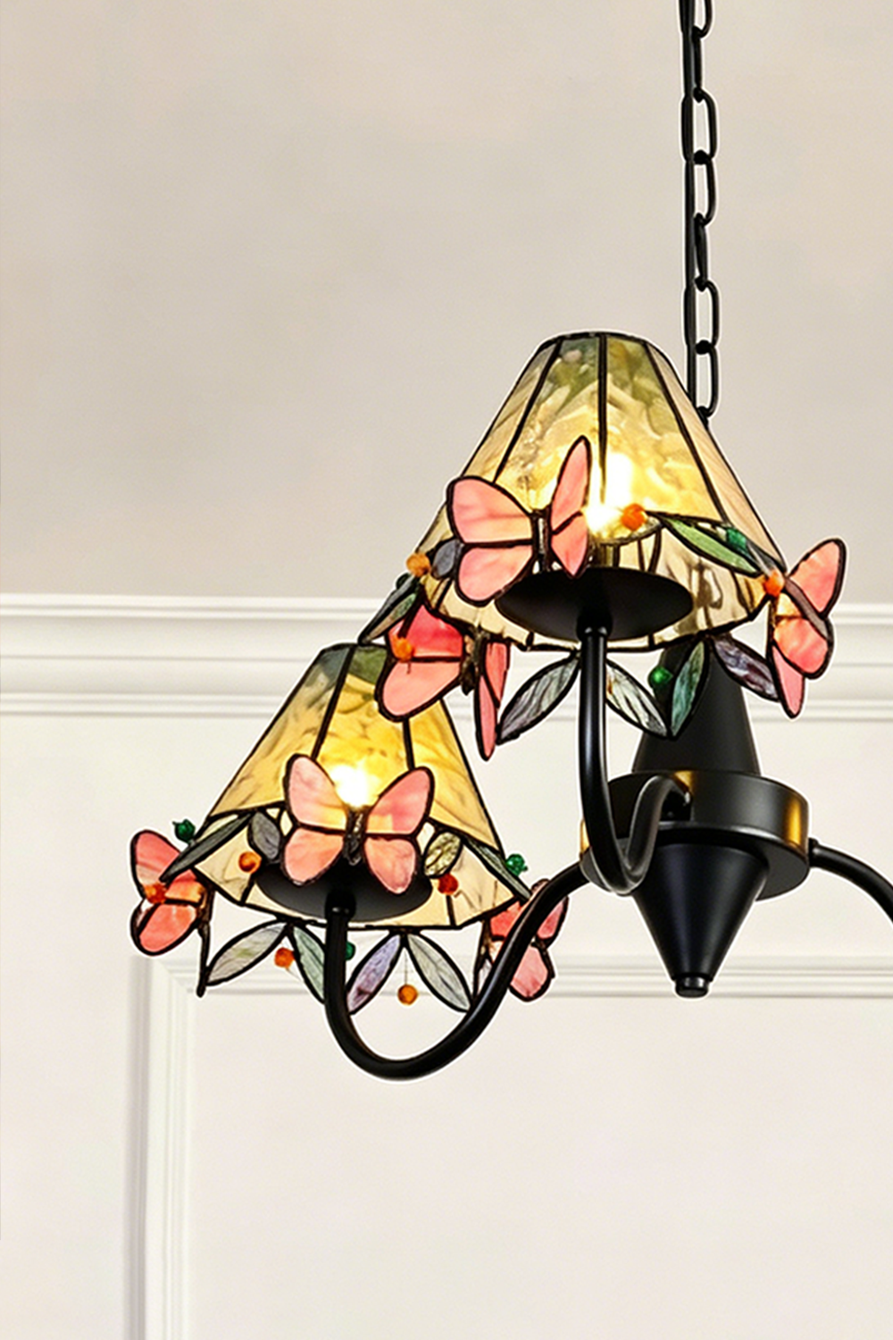 Seraphina Stained Glass Chandelier | Glass, Metal | Detailed side perspective of the illuminated stained glass shades highlighting the layered butterflies | Detail shot | vexa lamps