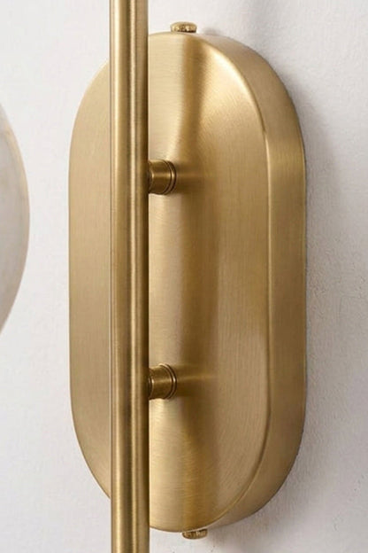 Close-up of the slim oval backplate of the Seraphine Alabaster Globe Wall Sconce in gold-toned finish.
