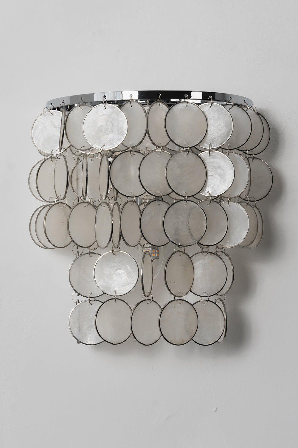 Unlit Shimmering Round Capiz Wall Lamp | Shell | Iron | Front product shot against a grey wall | vexa lamps