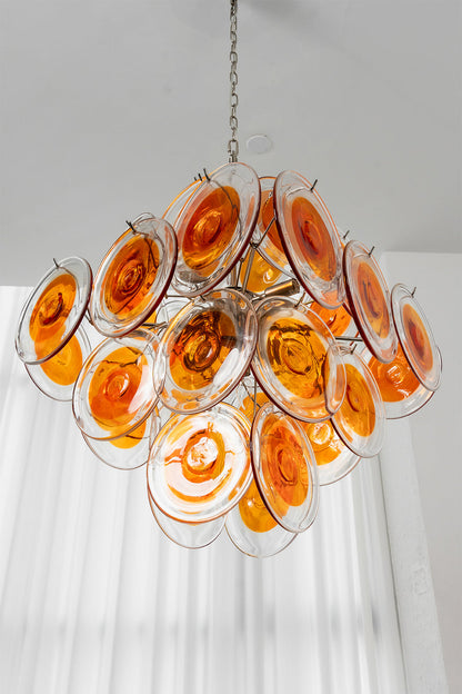 Angled view of Solari Amber Glass Chandelier | Metal, Glass | Hanging against white curtains and bright window | vexa lamps