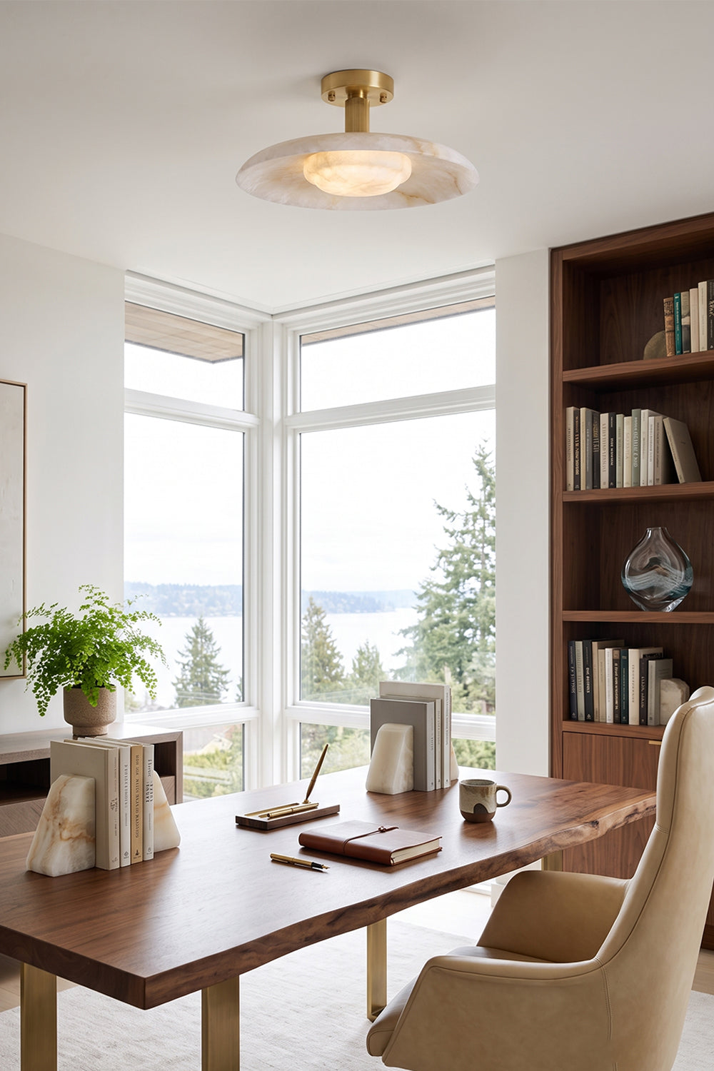 Solene Alabaster Round Ceiling Light | Office Ceiling Lamp | Providing warm overhead illumination in a bright home study space featuring a large wooden desk and scenic lake views through windows | vexa lamps