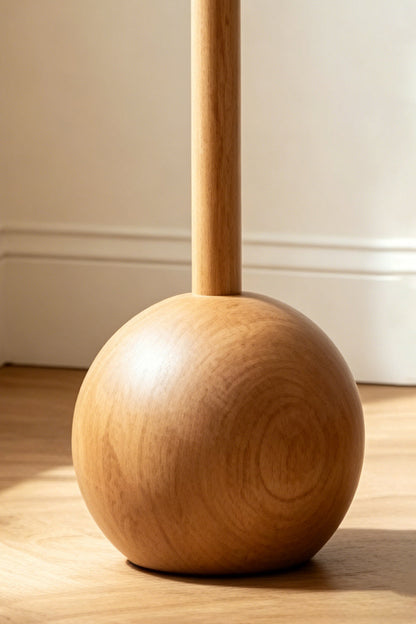Sphaerica Lignum Wood Floor Lamp | Metal, Wood, Fabric | Close-up detail of the spherical solid wood base and smooth vertical stem on a wooden floor | vexa lamps
