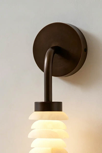 Stacked Strata Alabaster Wall Lamp | Alabaster, Metal | Close-up view of lit lamp on grey wall near console | vexa lamps