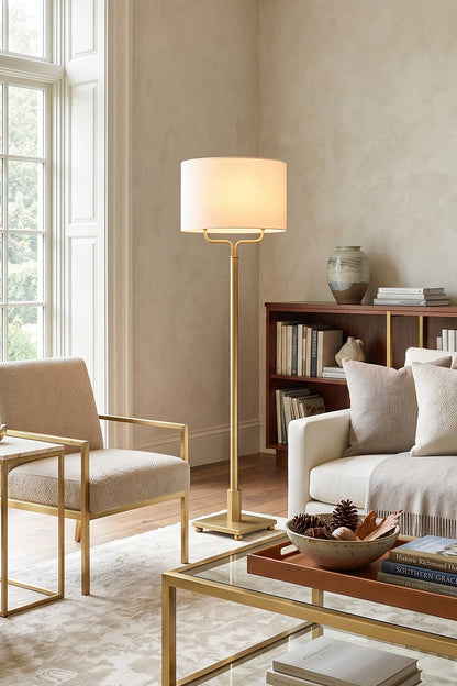 Sutton Modern Brass Floor Lamp in a stylish living room, featuring a white linen shade and antique brass finish.