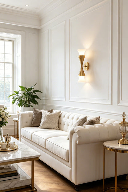 Sylvain Modern Torch Wall Sconce illuminating a stylish living room with white walls and elegant decor.
