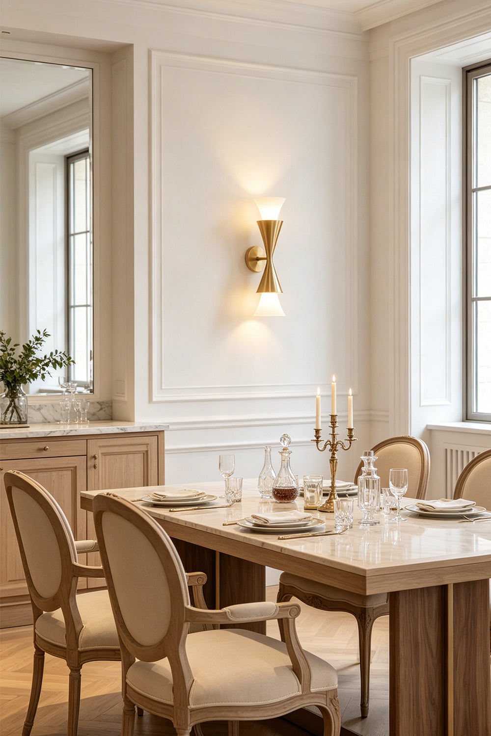 Sylvain Modern Torch Wall Sconce illuminating an elegant dining area with wooden furniture and a stylish table setting.
