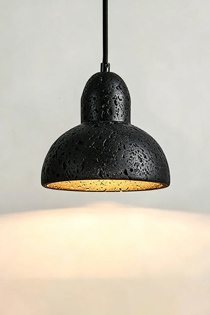Lit Black Travertine Pendant Light | Black Travertine, Metal, Glass | Close-up showing warm upward and downward glow | vexa lamps