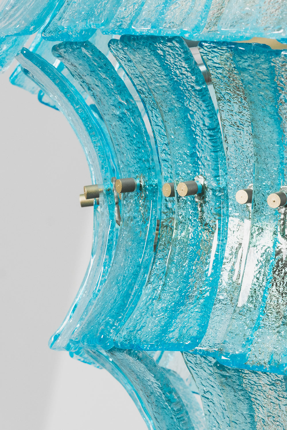 Thalassa Aquamarine Textured Glass Chandelier | Glass, Metal | Close-up side profile highlighting the wave-like rippled edges of the blue glass tiles and the gold frame attachments | Detail shot | vexa lamps