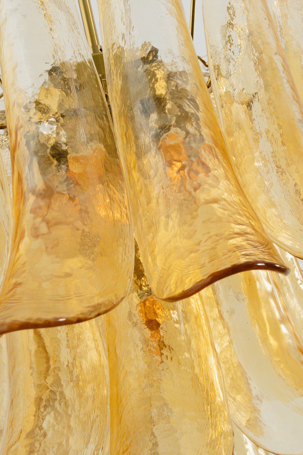Macro texture of amber lily glass petals | Glass | Close-up showing the rippled finish and warm glow | vexa lamps