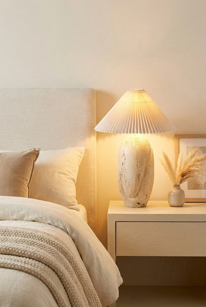 Bedside travertine lamp with pleated shade | Travertine, Fabric | On a white nightstand in a neutral bedroom | vexa lamps