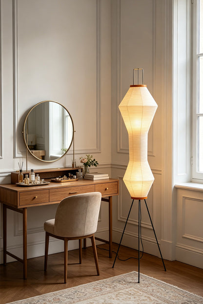 Verena Hourglass Paper Floor Lamp illuminating a cozy room with a desk and mirror.