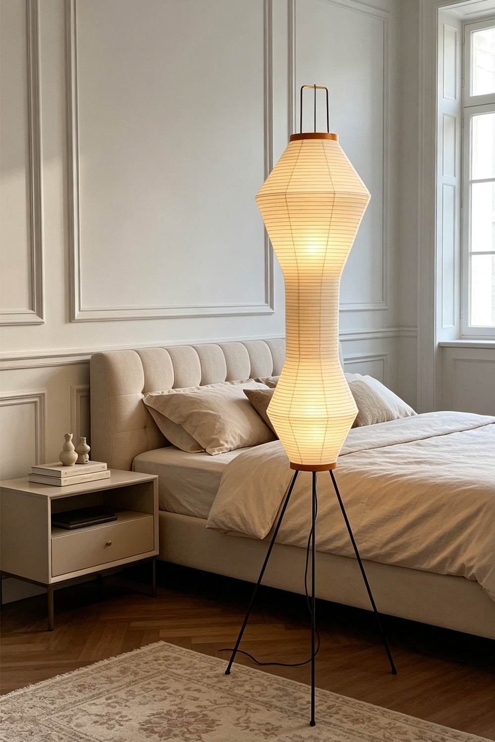 Verena Hourglass Paper Floor Lamp illuminating a bedroom with its sculptural glow and elegant hourglass design.