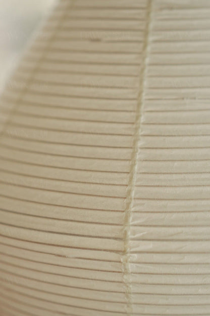 Close-up of the pleated paper shade of the Verena Hourglass Paper Floor Lamp, showcasing its texture and design.