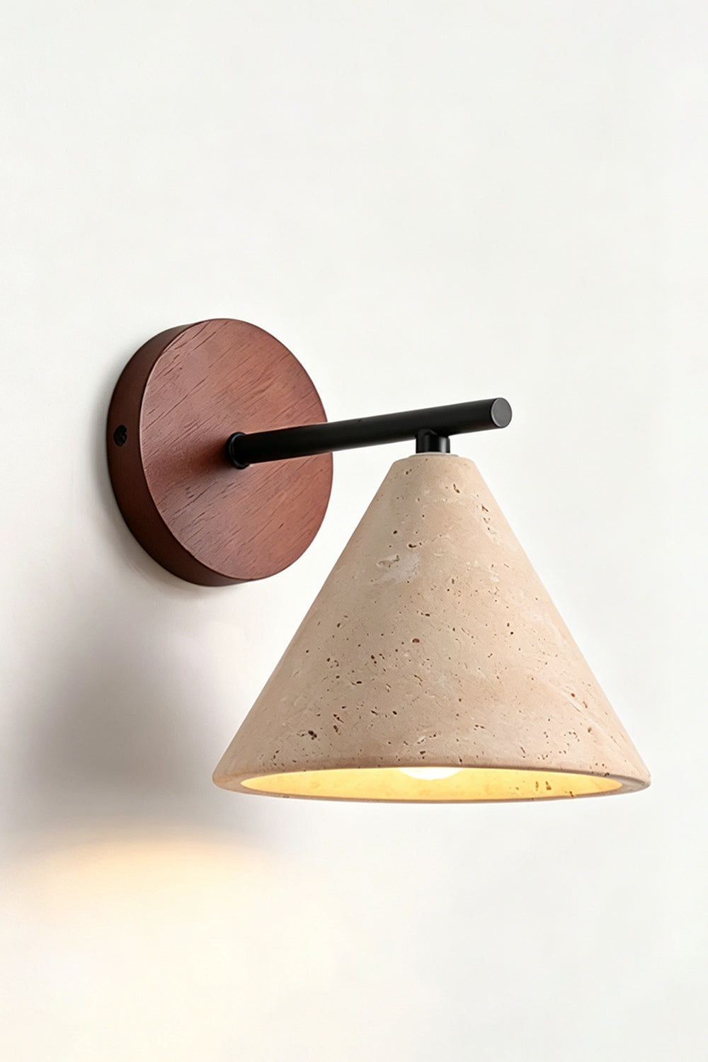 Vesper Cone Travertine Wall Light | Travertine, Wood | Side perspective of lit product on wall | vexa lamps