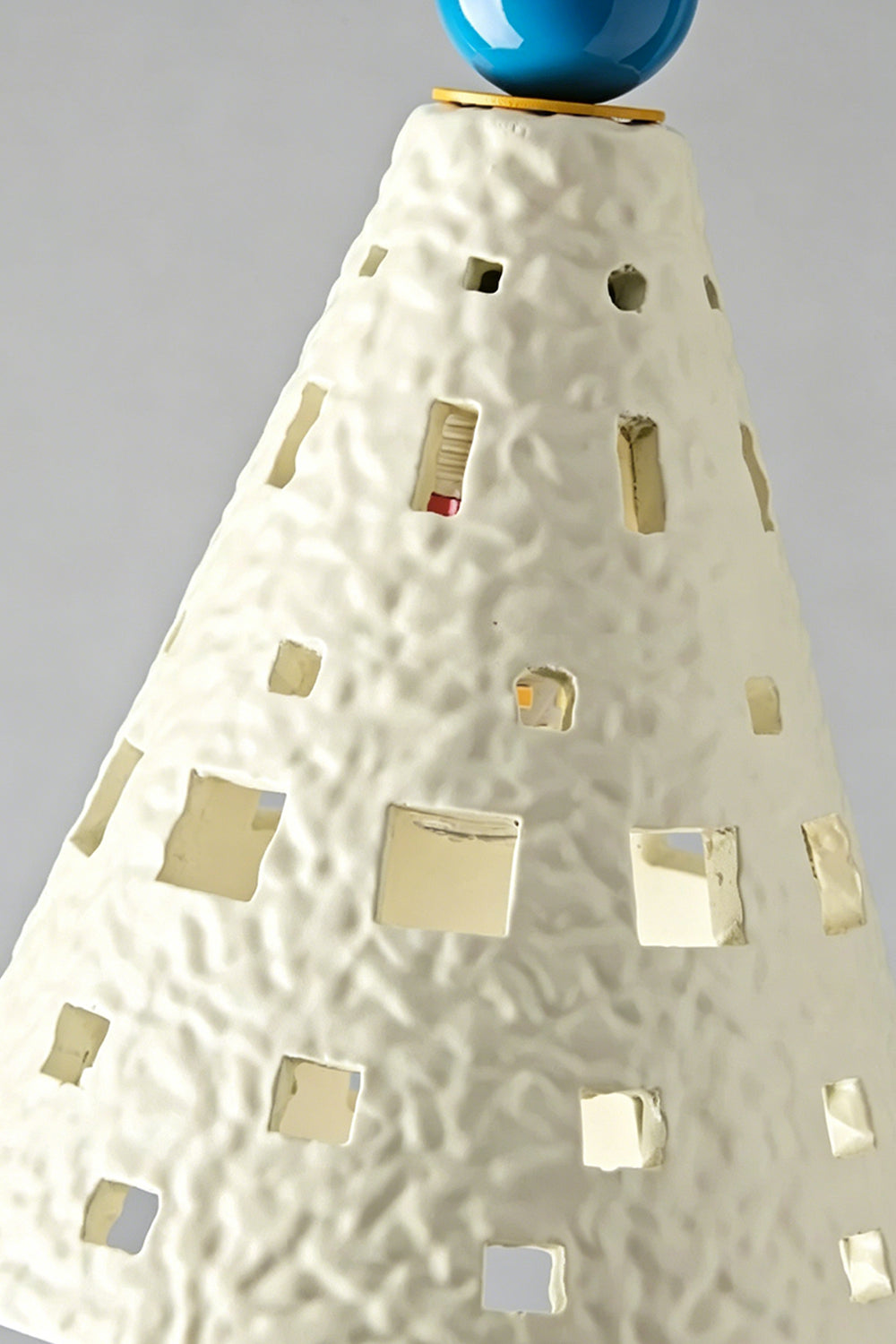 Carousel Horizon Ceramic Wall Sconce | Metal, Resin, Ceramics | Frontal view of the fully lit sconce against a plain wall, showing light filtering through the perforated shade | Isolated shot | vexa lamps